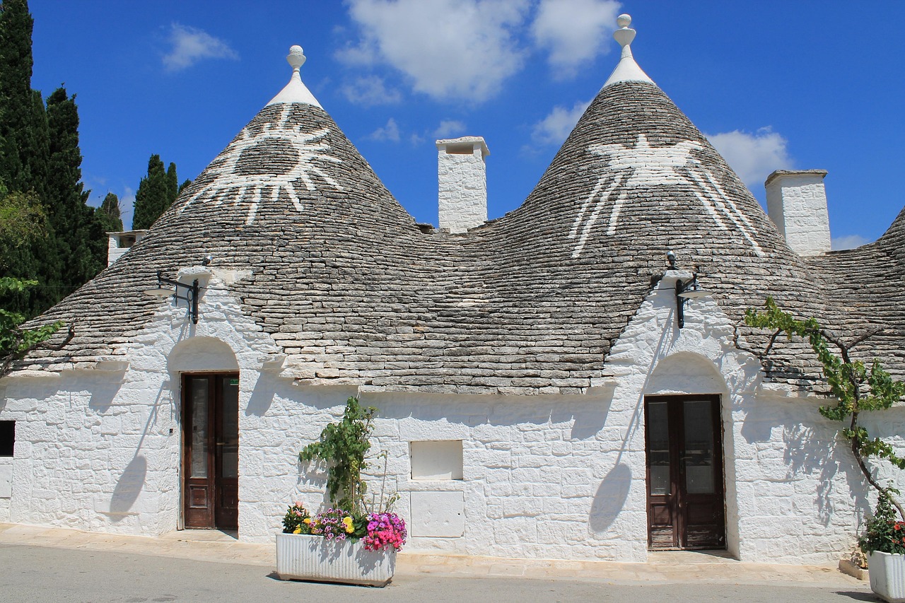 Interno accogliente di un trullo con letto matrimoniale e decorazioni tradizionali.