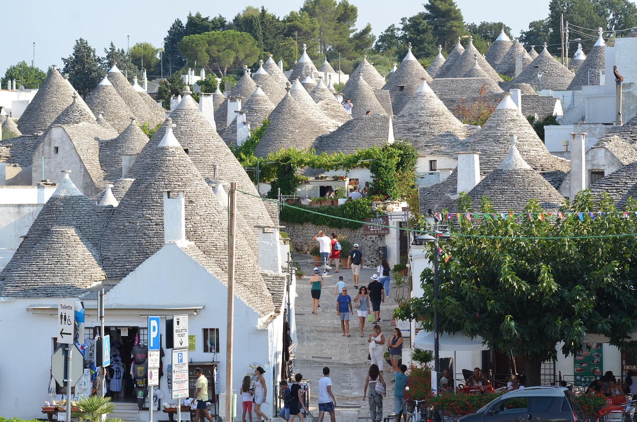 Spiaggia affollata in Puglia ad agosto, con ombrelloni e turisti. Alternative tranquille consigliate.