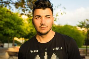 Dargen D'Amico sorridente con la fidanzata durante un evento pubblico.