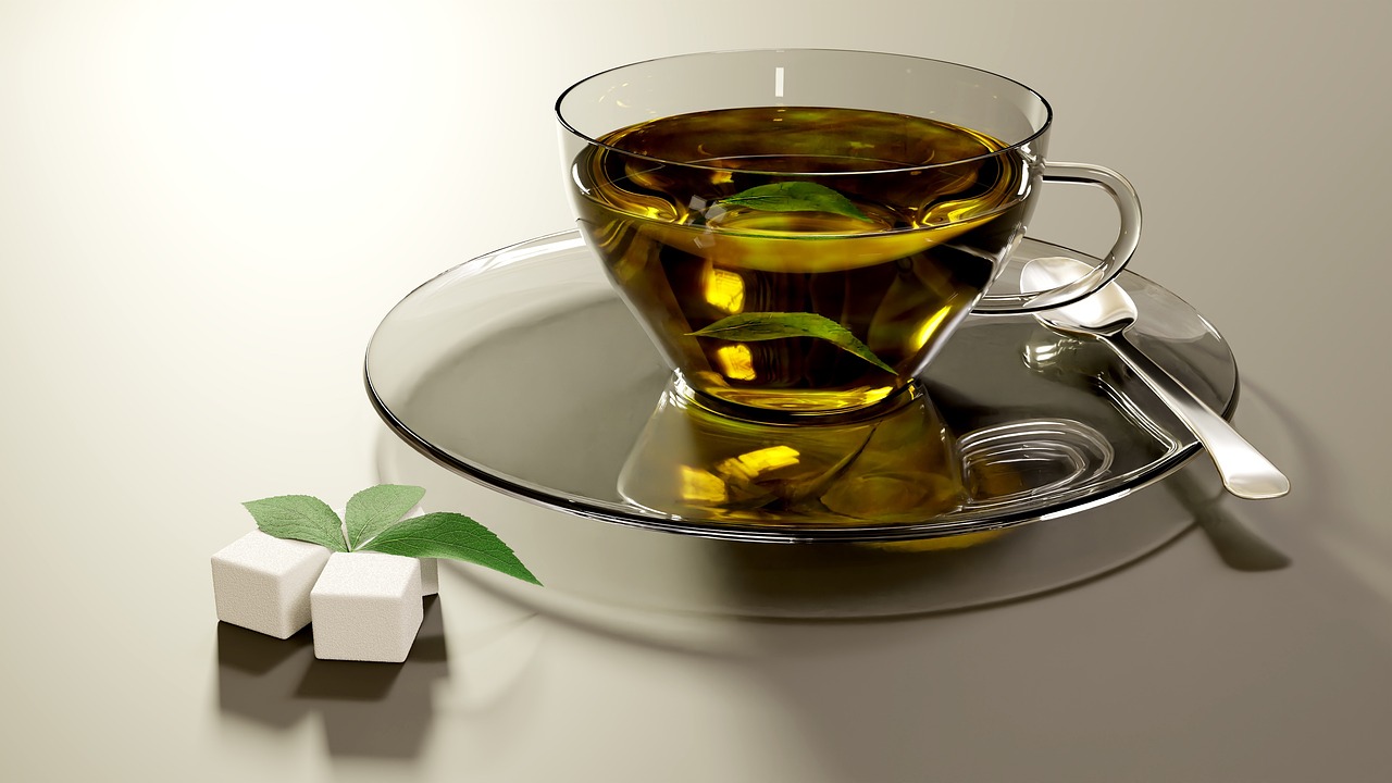 Immagine di una tazza di tè verde con foglie fresche, simbolo di eccesso di consumo e salute del fegato.