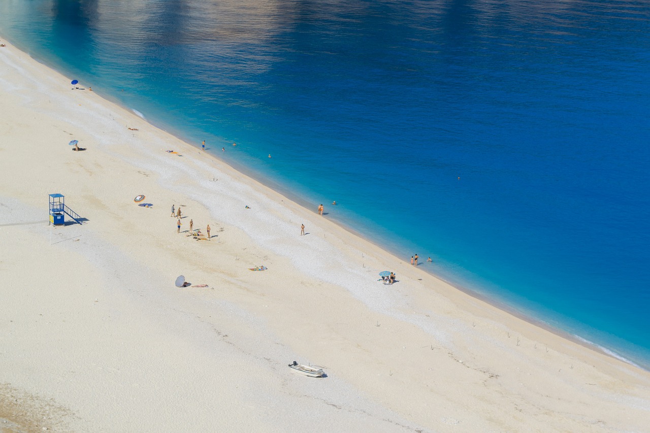 Spiaggia deserta a giugno, onde tranquille e sabbia dorata, ideale per una fuga lontano dalla folla.