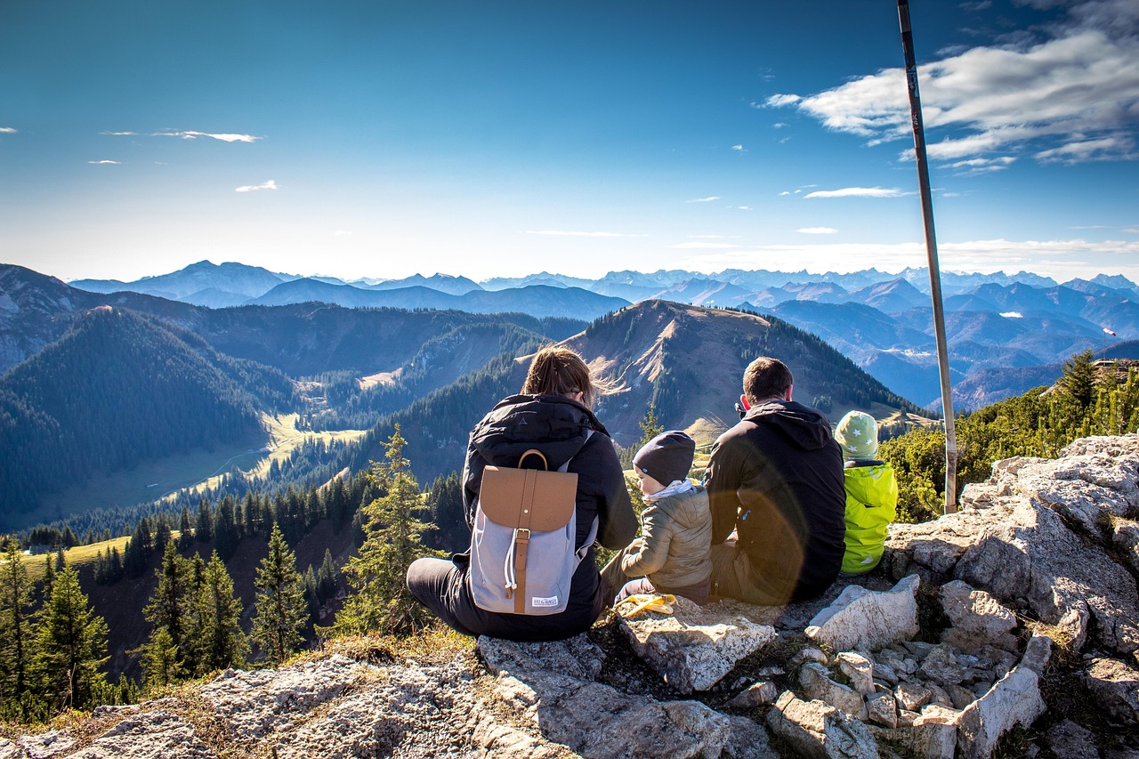 Famiglia che cammina su un sentiero panoramico in montagna, immersi nella natura.