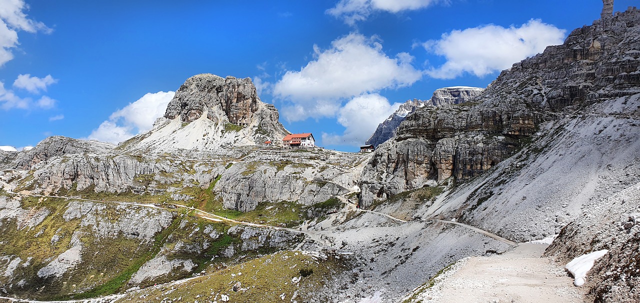 Escursionista su un sentiero della Alta Via delle Dolomiti n.1, circondato da paesaggi montani.