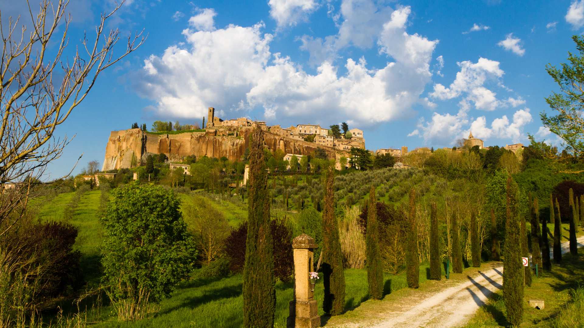 Sentiero panoramico in Umbria, immerso nella natura, con croce e simboli spirituali lungo il percorso.