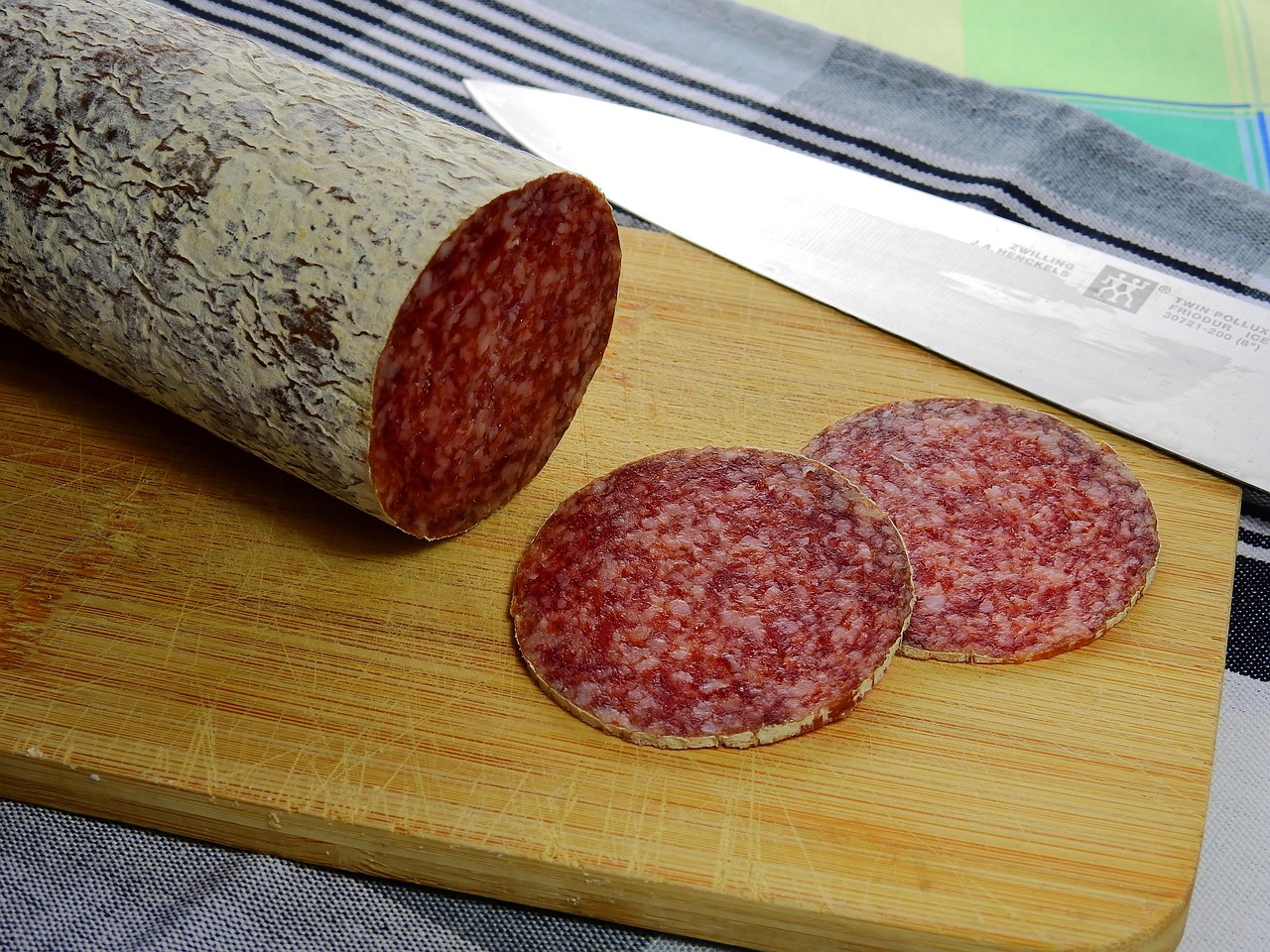 Immagine di un salame con etichetta che evidenzia ingredienti poco salutari.