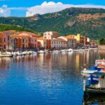 Borgo di pescatori in Sardegna, vista pittoresca con case colorate e mare cristallino.